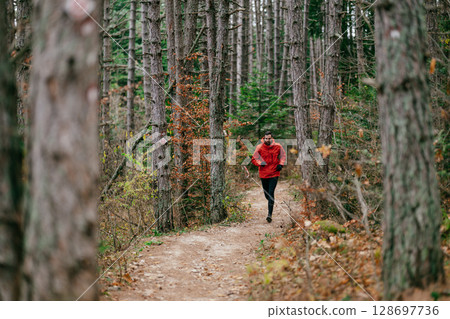 Jogger in Autumn Forest Trail 128697736