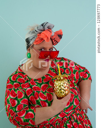 Playful Woman with Golden Pineapple Cup Wearing Watermelon Dress 128697773