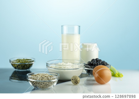 Food with calcium for health bones and joints. Products rich in calcium, supplements and X-ray film on white table. Healthy eating. Food for healthy bones, calcium source. Fronte view Food with calcium for health bones and joints. Products rich in calcium, supplements and X-ray film on white table. Healthy eating. Food for healthy bones, calcium source. Fronte view 128697898