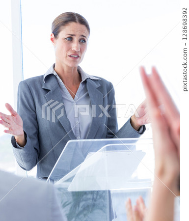 Businesswoman presenting at podium, engaging with audience in office meeting 128698392