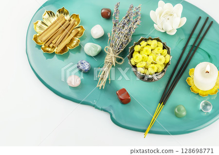 Self-care, healing composition with candle, aroma sticks, chakra stones, sandalwood sticks and dry flowers on green marble podium. Concept of relaxing at home, energy healing, meditation and me time 128698771