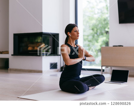 Young Beautiful Female Exercising, Stretching and Practising Yoga with Trainer via Video Call Conference in Bright Sunny House. Healthy Lifestyle, Wellbeing and Mindfulness Concept 128698826