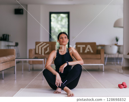 Young Beautiful Female Exercising, Stretching and Practising Yoga with Trainer via Video Call Conference in Bright Sunny House. Healthy Lifestyle, Wellbeing and Mindfulness Concept 128698832