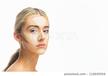 Posing woman wearing contour cream stripes in professional studio, with white backdrop Posing woman wearing contour cream stripes in professional studio, with white backdrop 128699569