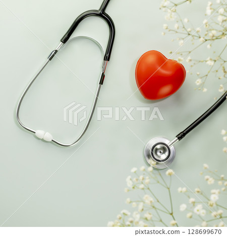 Red heart love shape hand exercise ball with stethoscope on blue background with flowers. Health care, organ donation, love and family insurance concept, world heart day. Flat lay 128699670
