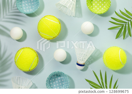 Summer sport activities card with yellow tennis balls, table tennis balls and shuttlecocks on blue background with palm leaves and shadows. Sport and healthy lifestyle. Tennis, table tennis, badminton Summer sport activities card with yellow tennis balls, table tennis balls and shuttlecocks on blue background with palm leaves and shadows. Sport and healthy lifestyle. Tennis, table tennis, badminton 128699675