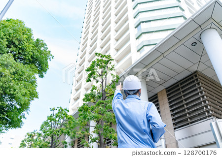 Middle-aged man in work clothes, back view Middle-aged man in work clothes, back view 128700176