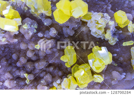 Striking mineral texture composed of purple and yellow crystals. Natural geological formation with intricate details for background or backdrop Striking mineral texture composed of purple and yellow crystals. Natural geological formation with intricate details for background or backdrop 128700284