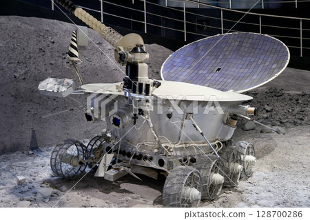 Moon rover on display at museum showcases engineering and technological achievements. Detailed design shows wheels, solar panels, and communication devices Moon rover on display at museum showcases engineering and technological achievements. Detailed design shows wheels, solar panels, and communication devices 128700286
