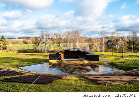 Empty open air stage in a park, with a sound projecting roof 128700341