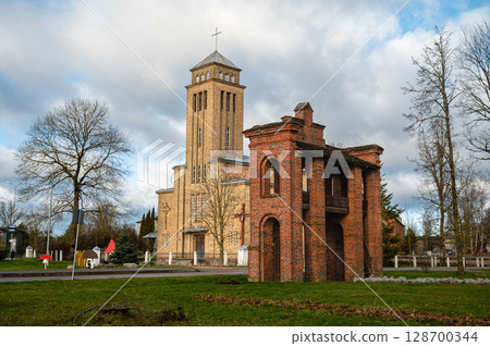 Old Catholic Church and red brick gates in city Akniste, Latvia 128700344