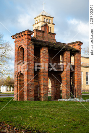 Old Catholic Church and red brick gates in city Akniste, Latvia 128700345