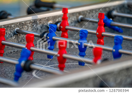 outdoor football table to play football with red and blue players, close up 128700394