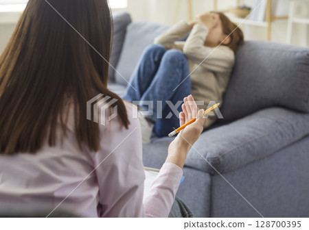 Psychologist trying to help a little child boy with his fears during therapy session. 128700395