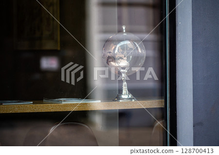 glass globe on table, view through window with street reflections, copy space glass globe on table, view through window with street reflections, copy space 128700413