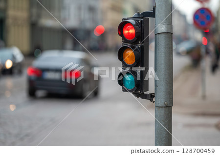 traffic light on the street junction with beautiful bokeh, city with cars in the background 128700459