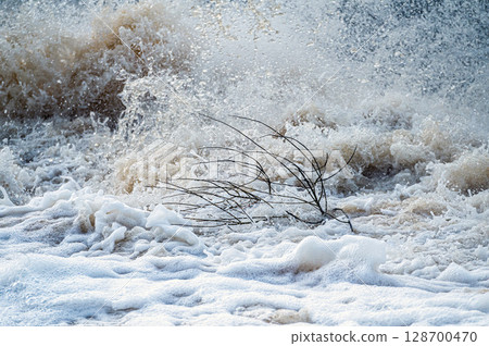 close up of flowing water, rapid water splashes of an white water river or stream, bubbly water 128700470