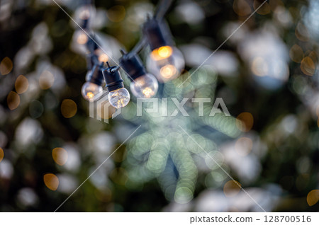 garland of light bulbs on defocused festive lights background, shallow depth of field, copy space garland of light bulbs on defocused festive lights background, shallow depth of field, copy space 128700516