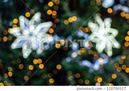 Blurred Christmas background. Christmas tree and lots of glowing lghts bulb out of focus 128700517