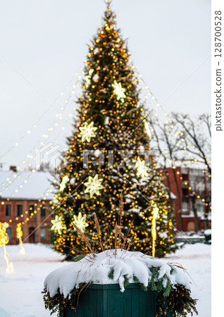 Defocused outdoor Christmas tree decorated with lights and decorations, shallow depth of field Defocused outdoor Christmas tree decorated with lights and decorations, shallow depth of field 128700528