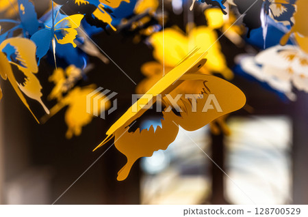 ceiling decorated with decorative colored paper butterflies, selective focus, blurred background 128700529