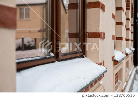 Window sill covered with heavy snow in winter, close up of building facades and window Window sill covered with heavy snow in winter, close up of building facades and window 128700530