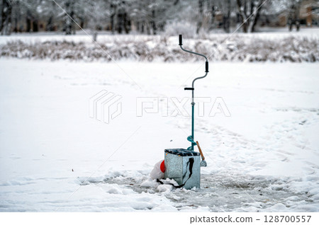 Fishing equipment for winter ice fishing on the background of a frozen river. 128700557