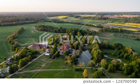 Jaunmoku medieval brick castle complex with pond and park near Tukums, Latvia, drone view Jaunmoku medieval brick castle complex with pond and park near Tukums, Latvia, drone view 128700590