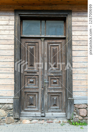 Rustic wooden door with intricate carvings at a historic building during daylight Rustic wooden door with intricate carvings at a historic building during daylight 128700699