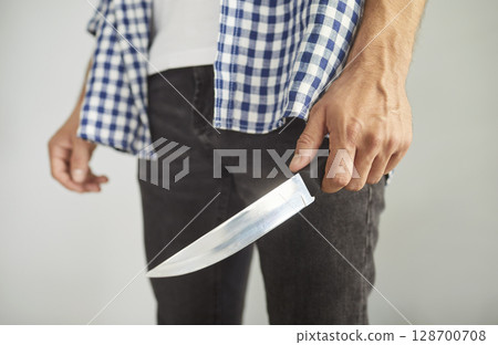 Criminal man holding knife to attack and kill, to hurt victim of domestic violence and abuse Criminal man holding knife to attack and kill, to hurt victim of domestic violence and abuse 128700708