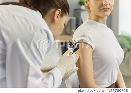 Patient arm skin and mole examination by doctor dermatologist with dermatoscope in hospital 128700828