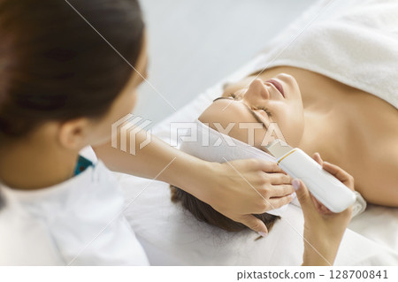 Cosmetologist beautician service, woman lying on medical treatment bed in clinic for facial therapy 128700841