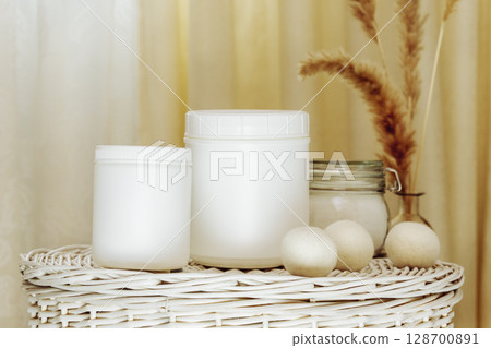 Natural laundry detergent mockup. Eco friendly home washing concept with bottles of washing powder or fabric softener on white laundry basket. Laundry day. Front view 128700891