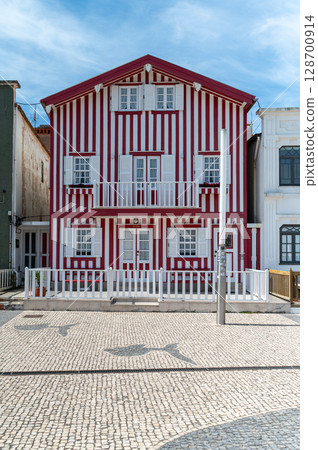 Charming red and white striped house in a historic coastal town during the day, Costa Nova, Portugal Charming red and white striped house in a historic coastal town during the day, Costa Nova, Portugal 128700914