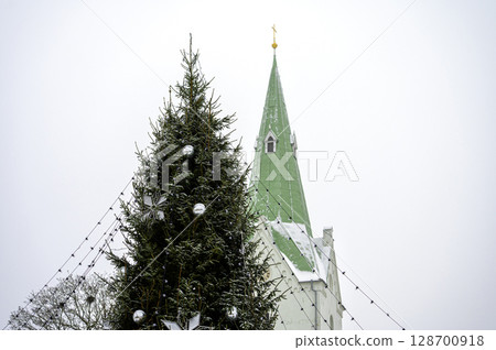 Decorated Christmas tree and church bell tower isolated on sky background, Dobele, Latvia 128700918