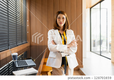 businesswoman portrait, Self confident young woman with crossed arms at office, People, candid portraits, business casual, self confidence, leadership concepts. businesswoman portrait, Self confident young woman with crossed arms at office, People, candid portraits, business casual, self confidence, leadership concepts. 128701659