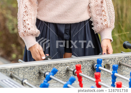 Engaging in a Friendly Outdoor Foosball Match Among Greenery on a Sunny Day 128701738