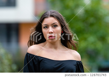 Young Woman Smiling in Off-Shoulder Top During Golden Hour in Urban Setting Young Woman Smiling in Off-Shoulder Top During Golden Hour in Urban Setting 128701743