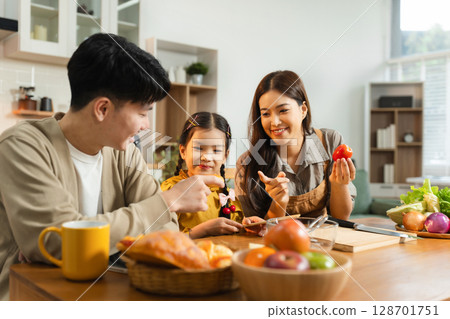 Smiling Asian family enjoying breakfast in weekend morning. 128701751