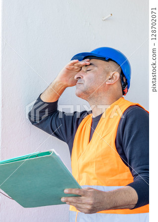 Tired and exhausted mechanical technician or building contractor. Bad news triggering headache 128702071