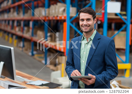 Working man holding tablet and checking inventory at warehouse workstation, copy space Working man holding tablet and checking inventory at warehouse workstation, copy space 128702204
