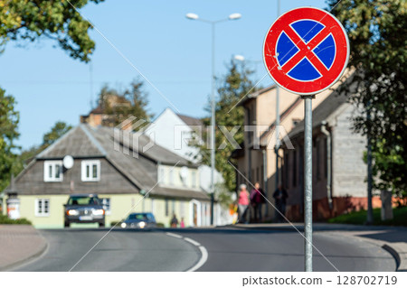 small city street scene with a road sign in the foreground and defocused traffic in the background small city street scene with a road sign in the foreground and defocused traffic in the background 128702719