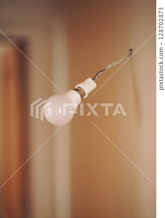 Vintage hanging light bulb over gray background  128702873