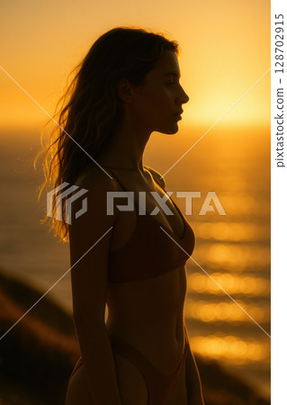 Solitary Silhouette Reflecting at Sunrise over Sparkling Ocean Horizon in Meditative Serenity 128702915