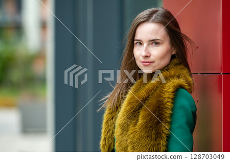 portrait of a woman at the red wall of a modern office building on a cool autumn day portrait of a woman at the red wall of a modern office building on a cool autumn day 128703049