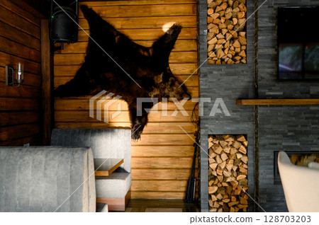 restaurant interior with wooden walls and ceiling, soft armchairs and sofas 128703203