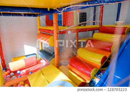 Play area for children. Slide and ball pit in the children's play center. Play area for children. Slide and ball pit in the children's play center. 128703223