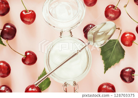 Healthy food still life with organic farm cherries and natural yogurt in glass jar on pink background. Healthy kid or school food and benefits of seasonal fruits concept. Flat lay, close up Healthy food still life with organic farm cherries and natural yogurt in glass jar on pink background. Healthy kid or school food and benefits of seasonal fruits concept. Flat lay, close up 128703375