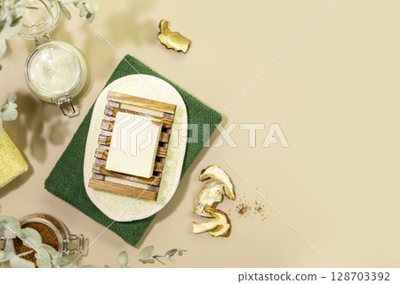 Natural mushrooms bath cosmetics. Mushroom soap, organic scrub, dry mushrooms and natural bath accessories on beige background. Wellness, skin care, spa relax treatment concept. Flat lay, copy space Natural mushrooms bath cosmetics. Mushroom soap, organic scrub, dry mushrooms and natural bath accessories on beige background. Wellness, skin care, spa relax treatment concept. Flat lay, copy space 128703392