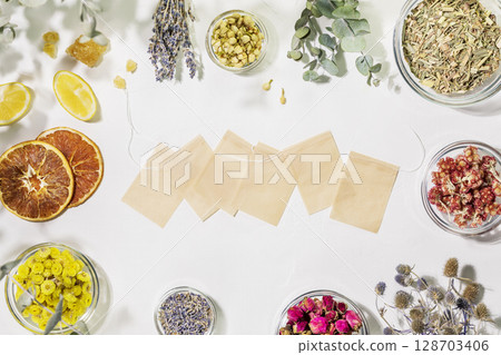 Organic healing tea from wild plants and flowers. Home herbal apothecary concept. Sustainable still life with tea paper bags and dry flowers and herbs, lemon on white background. Mockup, flat lay Organic healing tea from wild plants and flowers. Home herbal apothecary concept. Sustainable still life with tea paper bags and dry flowers and herbs, lemon on white background. Mockup, flat lay 128703406